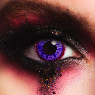 Close-up of an eye wearing Purple Glaze Halloween Contact Lenses with dramatic makeup and glitter.