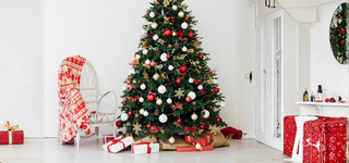 Classic red & green Christmas tree with ornaments and presents for festive decor ideas.