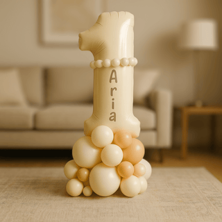 Personalised 1st Birthday Balloon Stack with name Aria in a cozy living room, featuring a large number 1 balloon atop a balloon base.