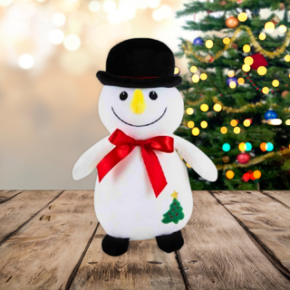 8Inch Snowman Soft Toy with top hat and red bow, standing on wooden floor, Christmas tree in background, festive holiday decor