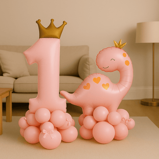 Prince & Princess Dino 1st Birthday Balloon Stack Display featuring a number '1' balloon with crown and pink dinosaur in a living room.