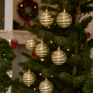 Close-up of a Christmas tree adorned with silver and gold baubles pack of 8, featuring elegant glitter swirl patterns.