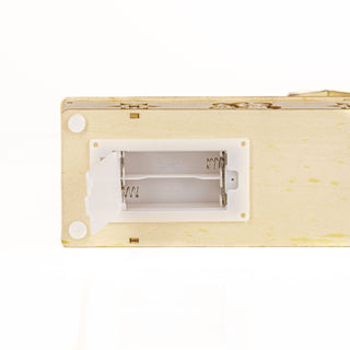 Close-up of battery compartment for the Christmas Village Candle Bridge, showcasing LED battery slots.