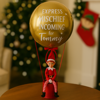 Gold Elf Arrival Balloon with "Express Mischief Incoming for Tommy" text on a festive background.