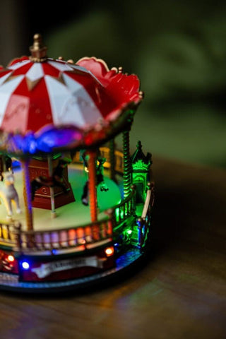 Festive LED Carousel Christmas Scene with rotating light display, featuring intricate details and charming holiday design.