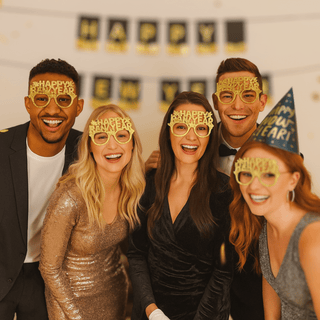 Group wearing Happy New Year Glasses 10 Pack, smiling at a party to celebrate New Year's Eve, perfect for countdown selfies and fun moments.