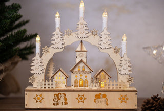 Christmas Village Candle Bridge with LED lights, featuring snow-topped houses and pine trees, perfect festive decoration for the season.