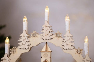 Christmas Village Candle Bridge with LED lights and festive design featuring snow-topped houses and pine trees.